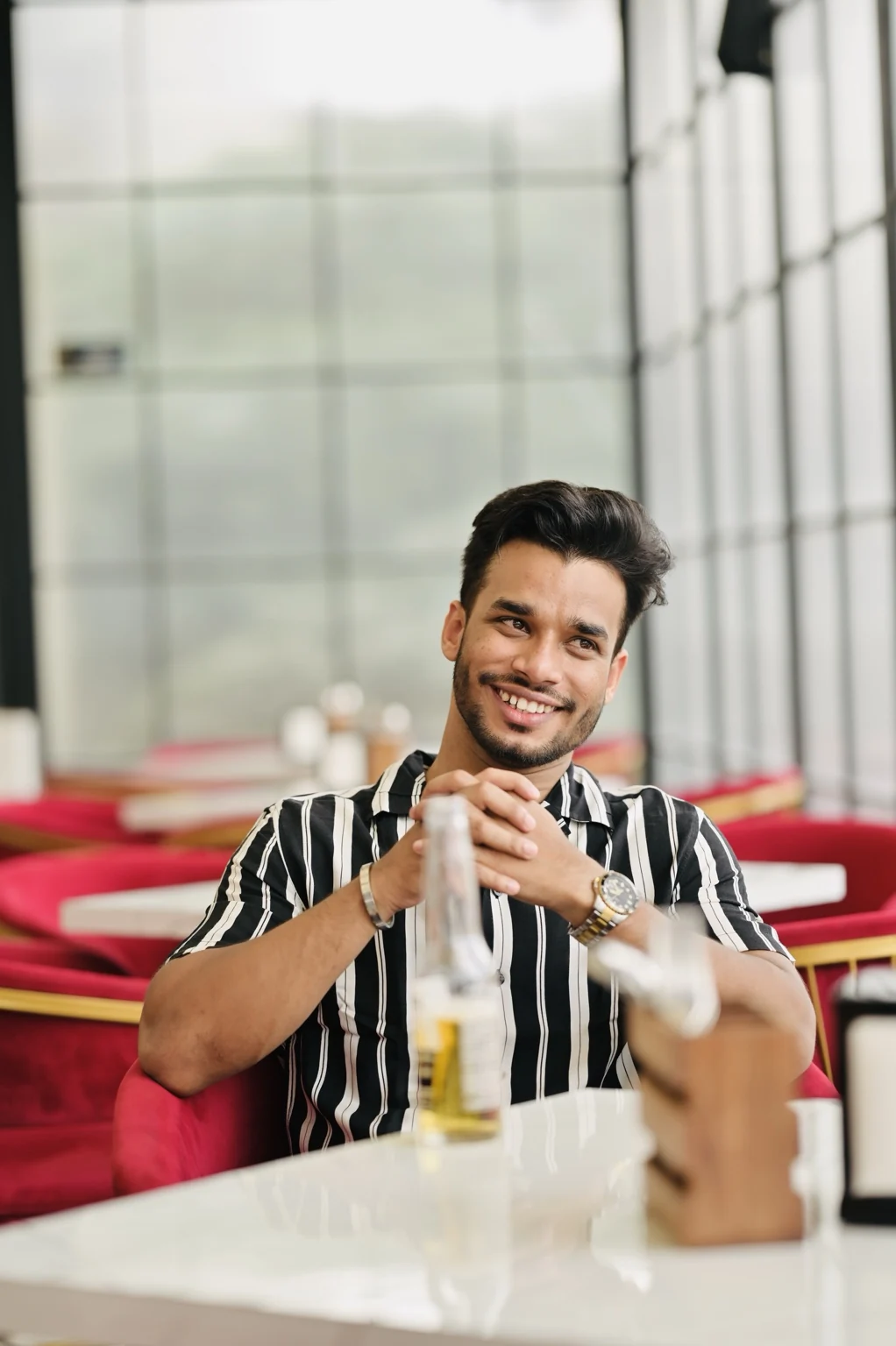Rahul Manhar in a striped shirt at a bright restaurant
